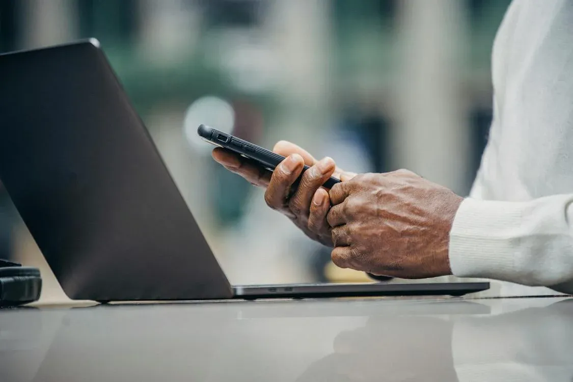 Man-op-laptop-en-telefoon.webp